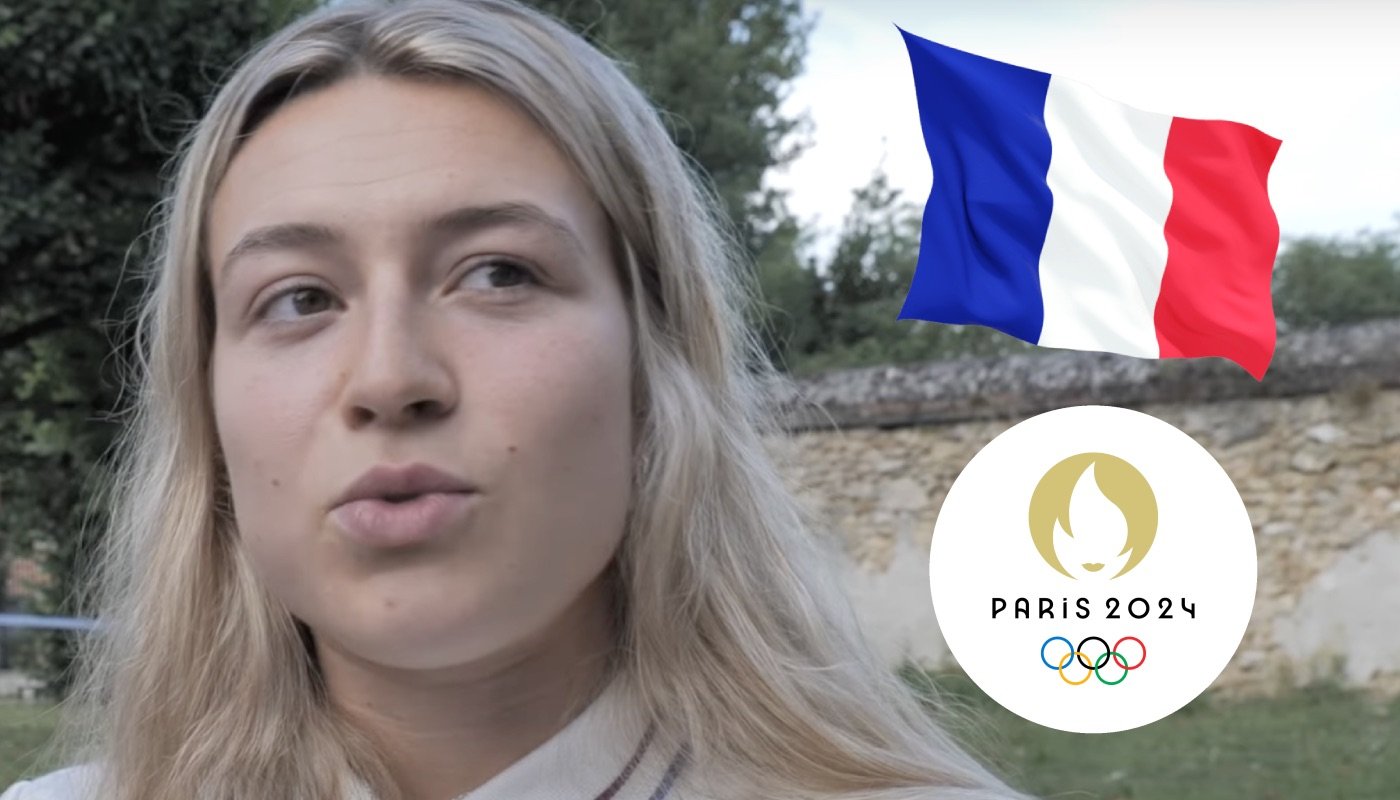 La cycliste française Mathilde Gros, ici accompagnée du drapeau tricolore et du logo des Jeux Olympiques de Paris 2024